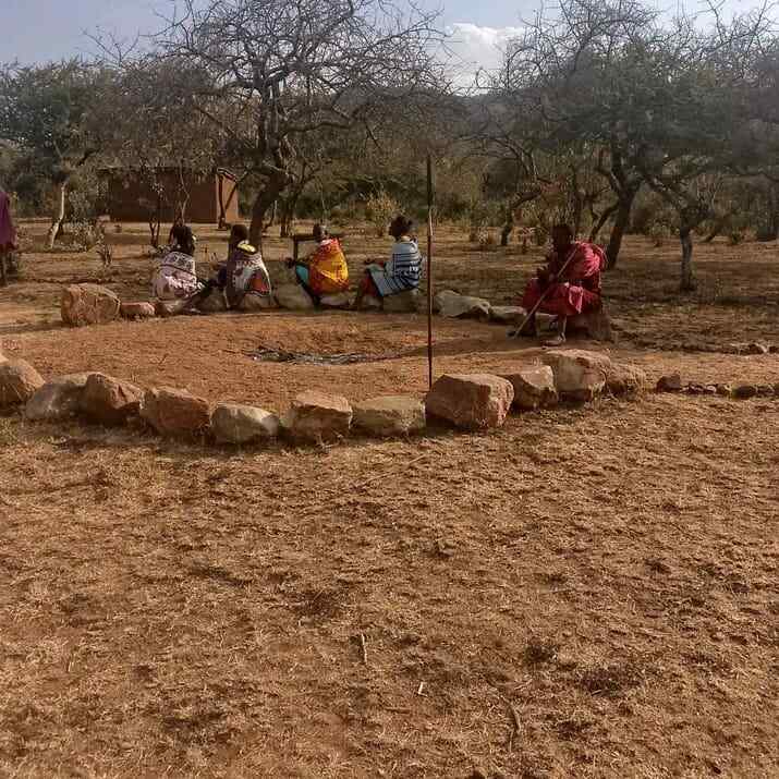 A circle of community elders gathered outdoors